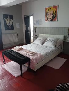 a bedroom with a large bed with a bench on it at Marie-Claire la grillade in Briare