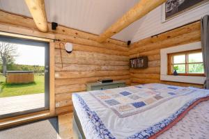 a bedroom with a bed and a large window at Log house with a sauna and hot tub in Atla! in Atla