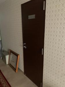 una puerta negra en una habitación con espejo en Tokyo Guest House 2020, en Tokio