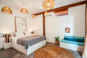 Un dormitorio con una cama y un sofá azul. en Batu Belig Living Apartment Seminyak, en Seminyak