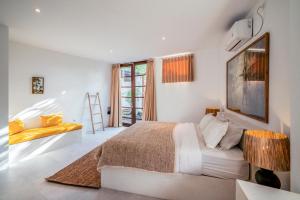 Dormitorio blanco con cama y silla amarilla en Batu Belig Living Apartment Seminyak, en Seminyak 53 fotos más