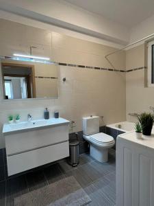 a bathroom with a sink and a toilet and a tub at Irida Apartment Nafplio in Nafplio