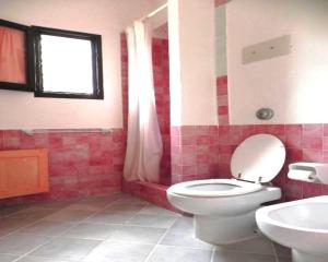 a bathroom with a white toilet and a sink at Seaside Apartment Baja Sardinia - 6pl August - 250 m from smeraldo beach in Baja Sardinia