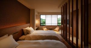 a hotel room with two beds and a window at くろしお想 in Shirahama