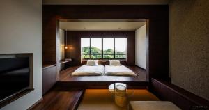 a bedroom with a bed with a large window at くろしお想 in Shirahama