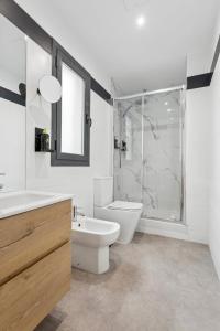 Un baño con ducha, inodoro y lavabo. en Limehome Madrid Calle de la Paloma, en Madrid 42 fotos más