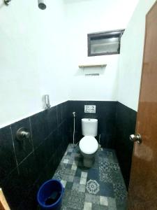 La salle de bains est pourvue de toilettes et de carrelage noir et blanc. dans l'établissement FHStay Malioboro, à Timuran