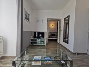 a living room with a glass table with books on the floor at Le Mas des Loges - Les Vans / Chambonas in Chambonas