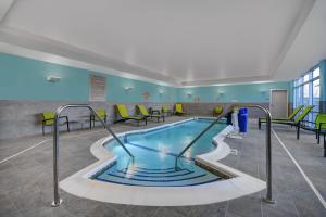 - une piscine dans le hall de l'hôpital avec des chaises et des tables dans l'établissement SpringHill Suites by Marriott St. Paul Arden Hills, à Arden Hills