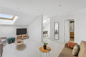 Una sala de estar con un sofá y un televisor. en Limehome Madrid Calle de la Paloma, en Madrid