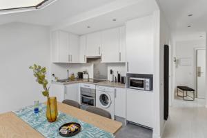 une cuisine avec des placards blancs et une table avec une plaque de cuisson. dans l'établissement limehome Madrid Calle de la Paloma, à Madrid