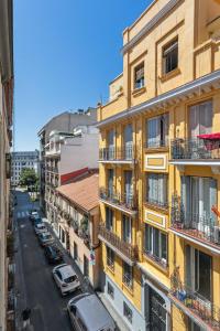 un immeuble avec balcon et voitures dans une rue dans l'établissement limehome Madrid Calle de la Paloma, à Madrid