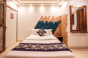 a bedroom with a bed with a blue headboard at Ananya Residency in Port Blair