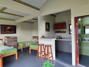 a kitchen with a counter and stools in a room at The Green Shack in Quatre Soeurs