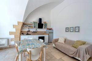 eine Küche und ein Wohnzimmer mit einem Tisch und einem Sofa in der Unterkunft Dimora Storica Minioti intera in Arnesano
