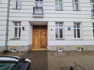 a building with a wooden door in front of it at Fantastic Apartments - OK11 Room - C in Warsaw