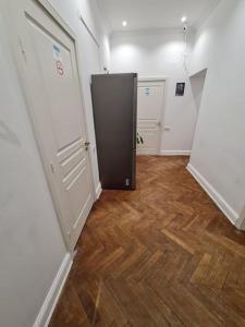 a hallway with two doors and a wooden floor at Fantastic Apartments - OK11 Room - C in Warsaw
