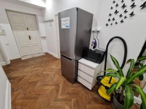 a kitchen with a refrigerator and a potted plant at Fantastic Apartments - OK11 Room - C in Warsaw