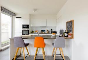 uma cozinha em plano aberto com 2 cadeiras e um balcão em B&B Le Murmure de l'eau - Chambre d'hôte Urbaine - Namur em Namur