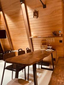 uma sala de jantar com uma mesa de madeira e cadeiras em Dongbok Sanjang Jeju em Jeju