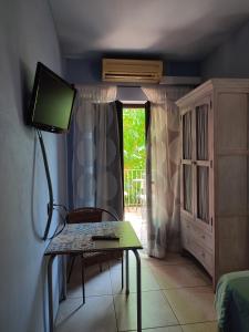 een kamer met een tafel, een televisie en een raam bij HOTEL PASTERAL RIU TER in La Cellera de Ter