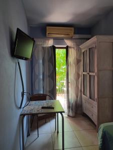 a room with a table with a television and a window at HOTEL PASTERAL RIU TER in La Cellera de Ter
