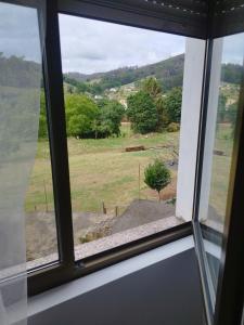 una ventana con vistas al campo desde una casa en Apartamentos Trevias, en Trevías
