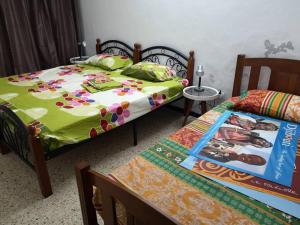 a bedroom with two beds and a table with a magazine at Appartement meublé au Héron in Djibouti