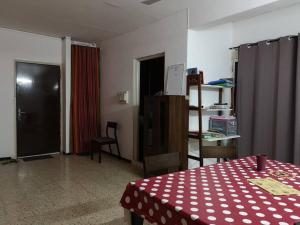 Cette chambre comprend une table avec un tissu de table rouge et blanc. dans l'établissement Appartement meublé au Héron, à Djibouti