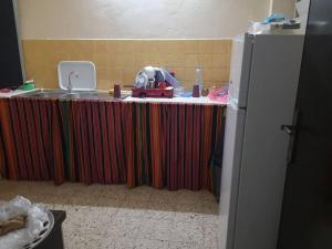 une table avec un chiffon de table coloré et un évier dans l'établissement Appartement meublé au Héron, à Djibouti