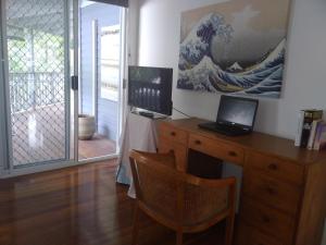 Zimmer mit einem Schreibtisch und einem Laptop darauf in der Unterkunft Near to Everything Yet in a Rainforest setting in Tewantin