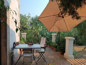 a table and chairs with an umbrella on a patio at Casa delle Meridiane in Canicattini Bagni