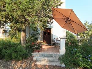 a patio with an umbrella in front of a house at Casa delle Meridiane in Canicattini Bagni