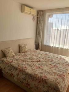 a bedroom with a large bed with a window at Квартира у моря in Sveti Vlas