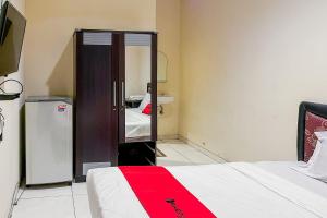 Cette chambre comprend un lit et une porte coulissante en verre. dans l'établissement RedDoorz At Graha 99 Simomulyo, à Surabaya