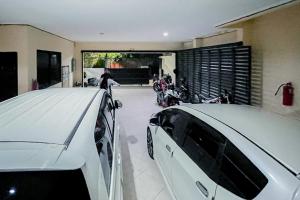 a white car parked in a garage with motorcycles at RedDoorz At Graha 99 Simomulyo in Surabaya