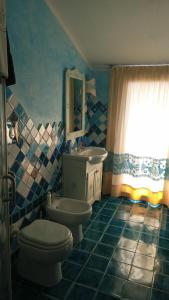 ein blau gefliestes Bad mit WC und Waschbecken in der Unterkunft Sa Reposada in Càbras