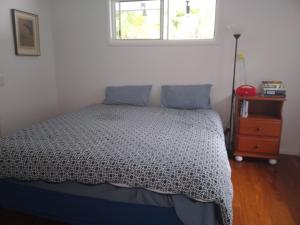 1 dormitorio con cama, ventana y vestidor en Near to Everything Yet in a Rainforest setting, en Tewantin