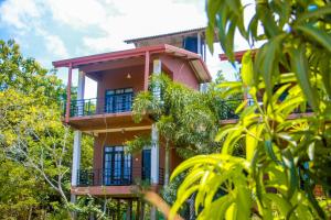 un edificio con balcones y árboles delante de él en Darshani Lodge, en Sigiriya