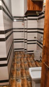 baño con paredes a rayas en blanco y negro y aseo en Hotel High Society, en Kota