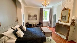 a bedroom with a large bed and a fireplace at B&B Maison d'Hôtes - Château de Jouques in Gémenos