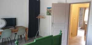 um quarto com uma secretária, uma porta, uma mesa e cadeiras em la boufanelle em Montséret
