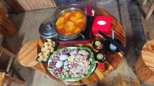a wooden table with a plate of food on it at Lù Homestay Tà Xùa in Bắc Yên