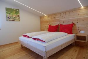 a bed in a room with a wooden wall at Wolfhof_Ritten in Auna di Sopra