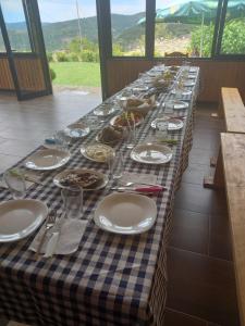 einen langen Tisch mit Teller mit Lebensmitteln drauf in der Unterkunft Guest House Qafe Dardha - Tomorr National Park in Dardhë