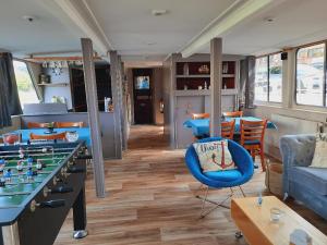 a room with couches and a table with a game at Gîte Le Sambre in Thuin