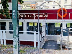 a red and white bus parked next to a building at Gîte Le Sambre in Thuin