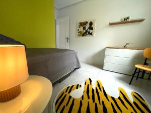 1 dormitorio con 1 cama y 1 mesa con lámpara en Apartamento La Peatonal, en Hervás