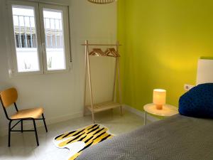 a bedroom with a bed and two chairs and a window at Apartamento La Peatonal in Hervás