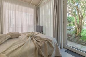 een slaapkamer met een bed en een groot raam bij The Secret Garden in Varenna